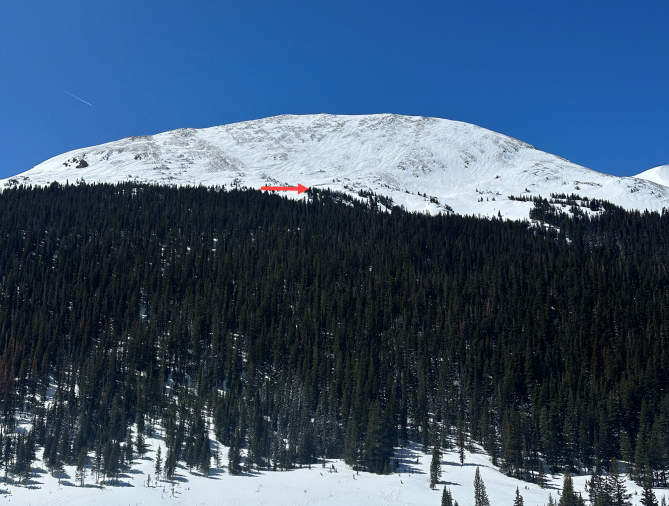 <b>Figure 3:</b> Looking from across the valley towards the wind-scoured northeast face of Mount Bethel and the avalanche. The red arrow marks Worker 1’s approximate path through the terrain. (Image taken April 9, 2024). (<a href=javascript:void(0); onClick=win=window.open('https://classic.avalanche.state.co.us/caic/media/full/acc_876_52629.png','caic_media','resizable=1,height=820,width=840,scrollbars=yes');win.focus();return false;>see full sized image</a>)