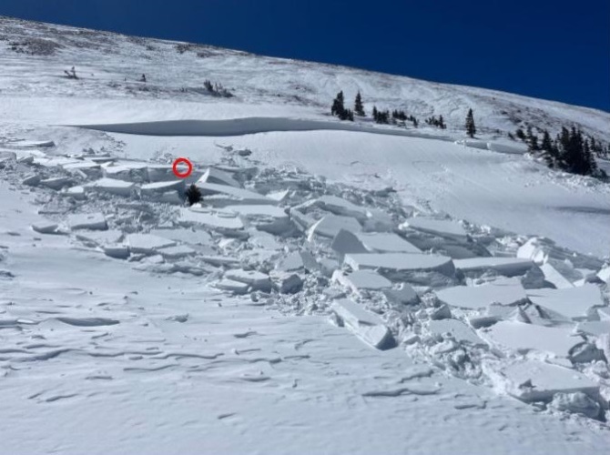 <b>Figure 5:</b> Looking up at the avalanche. The red circle marks Worker 1’s approximate location when he triggered the avalanche. The deepest part of the crown face was over 4 feet deep (146 cm). It tapered to less than a foot deep on the edges. (Image taken April 9, 2024). (<a href=javascript:void(0); onClick=win=window.open('https://classic.avalanche.state.co.us/caic/media/full/acc_876_52631.jpg','caic_media','resizable=1,height=820,width=840,scrollbars=yes');win.focus();return false;>see full sized image</a>)